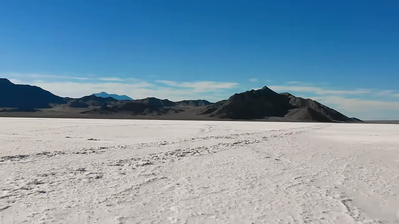 Expansive white salt surface of the Bonneville Salt Flats with surrounding mountains in the distance