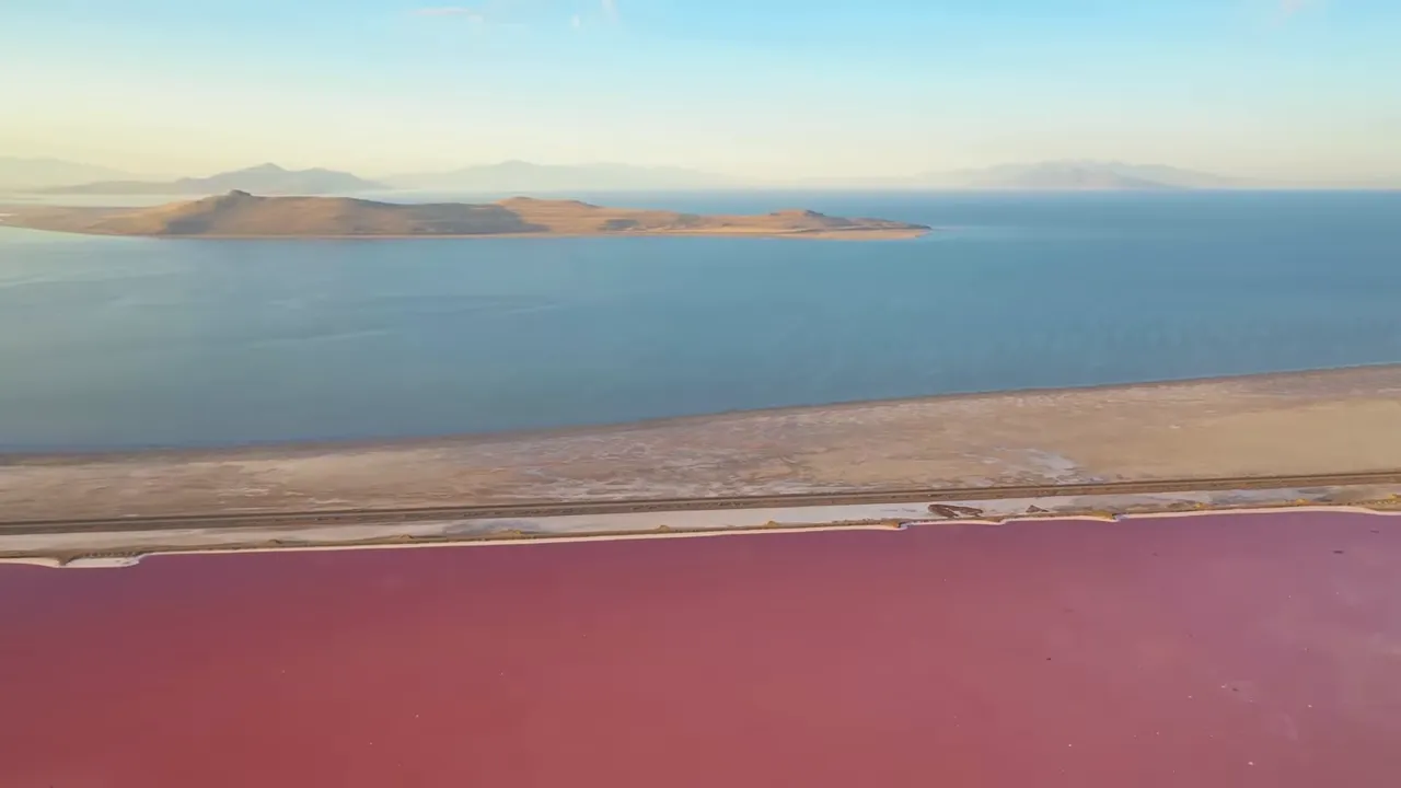Aerial view of colorful mineral lakes contrasting with blue water at a salt basin